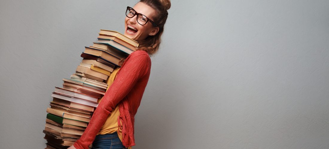 Eine Schülerin trägt ein Stapel Bücher